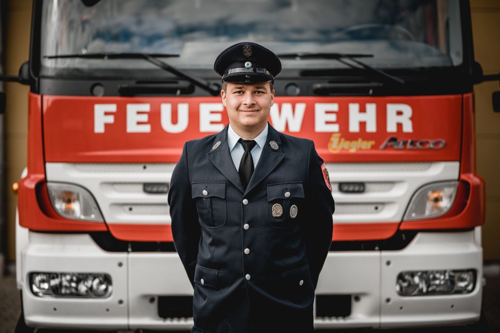 Christian Keck, Jugendwart FF Eibelstadt vor Feuerwehrfahrzeug HLF